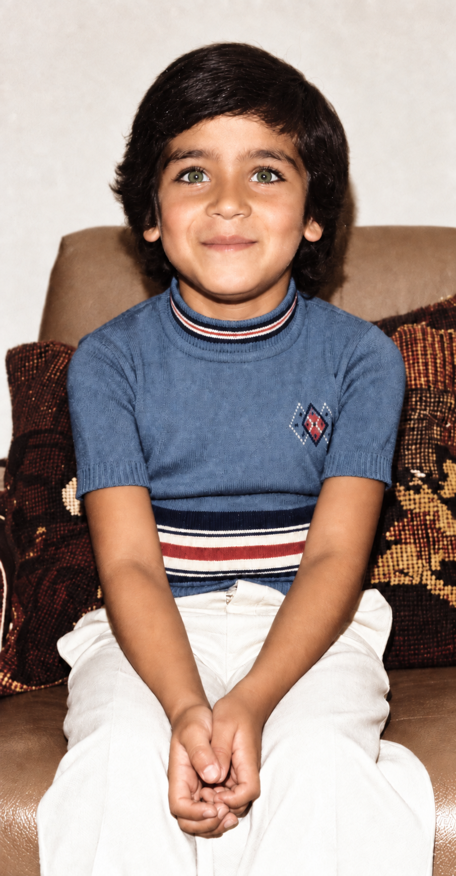 Colorized childhood portrait of Adriano at age eight, seated with clasped hands in São Vicente, Brazil